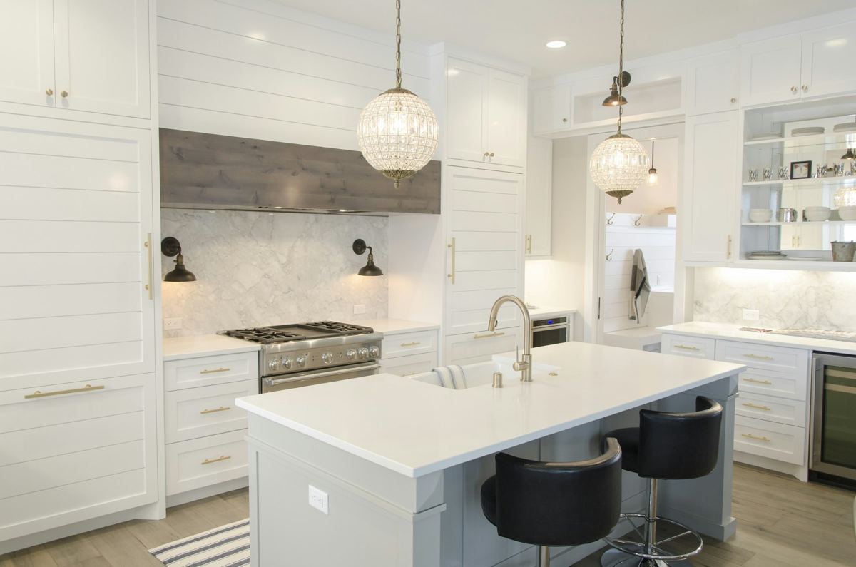 White kitchen with island, pendant lights and shaker-style cabinets