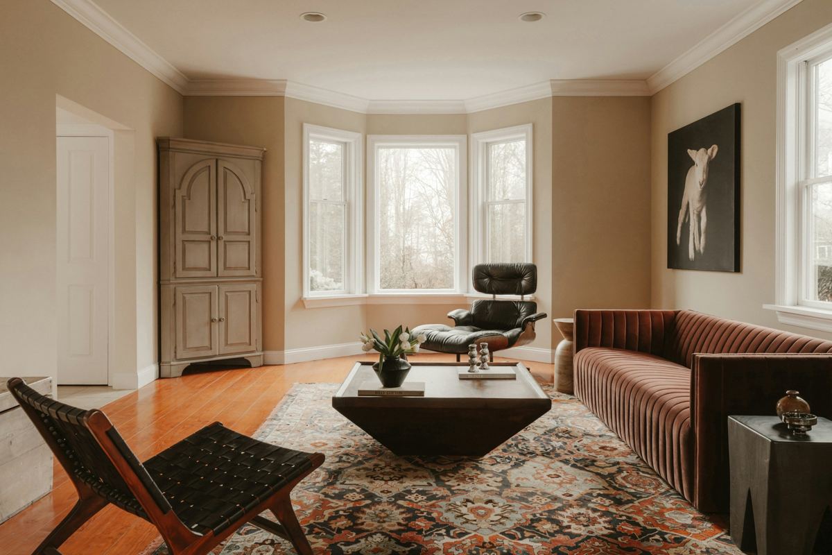 Living room with velvet sofa, leather lounge chair and patterned rug